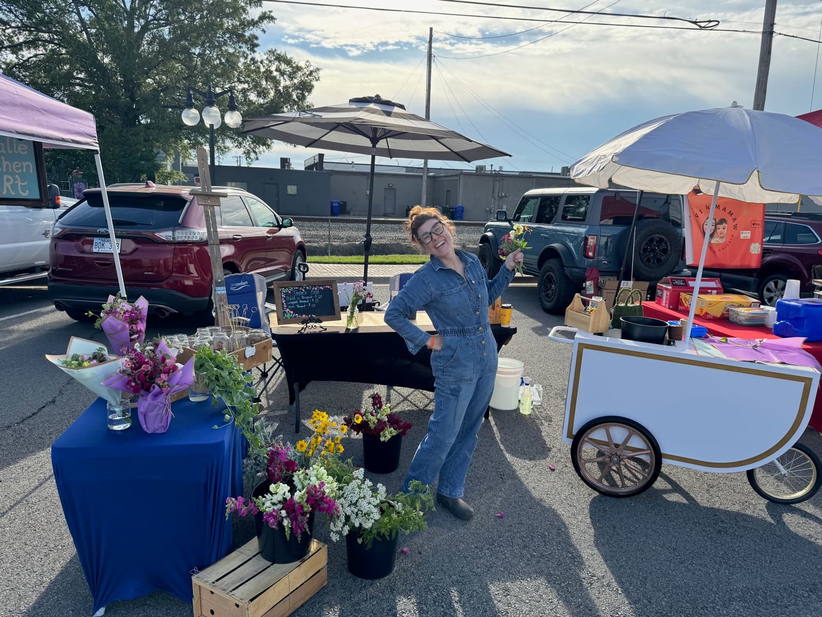 Lauren at her market booth surrounded by fresh flower bouquets